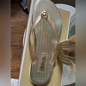 SIZE 10 - BRAND NEW MK GOLD FLIP FLOPS. GREAT FOR SUMMER OR TO WEAR AROUND HOUSE